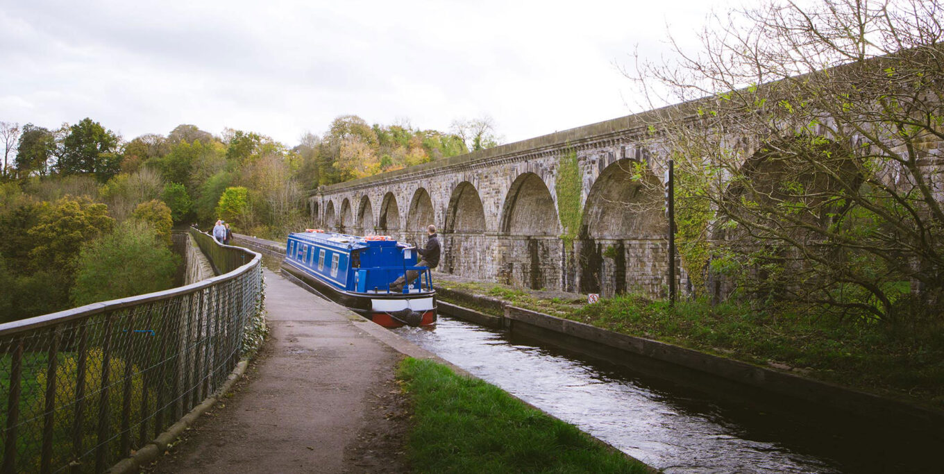 Cwch yn croesi dyfrbont ddŵr y Waun wrth ochr y draphont / A boat crossing the Chirk aqueduct alongside the viaduct